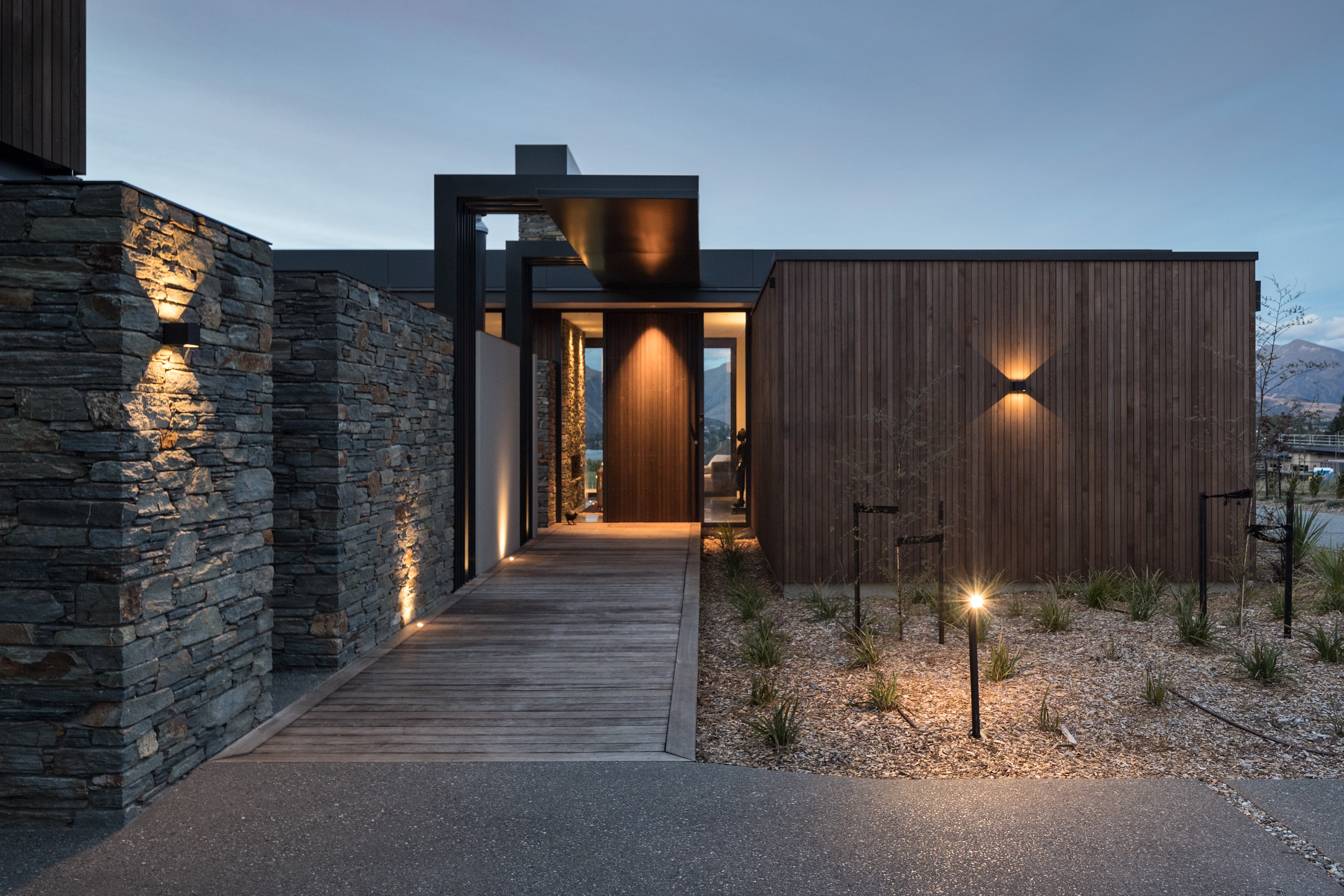 Exterior of modern Wanaka residence mixing stone, wood, and steel